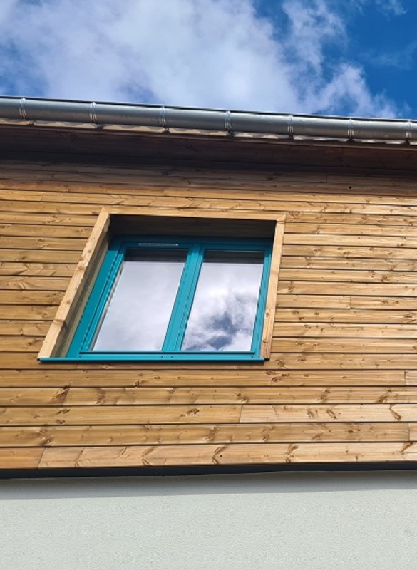 façade maison bois avec fenêtre double battants bleue fabrication de menuiseries bois standard et hors cote De La Rosa Industrie